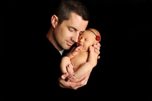 Dad cuddling newborn daughter cheek to cheek, Photo credit Refuge Photography in Frisco, TX