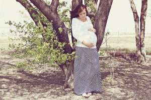 Pregnant mom by tree cradling her belly, Photo credit Refuge Photography in Frisco, TX