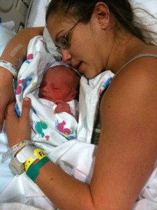 mother cuddles newborn in hospital bed